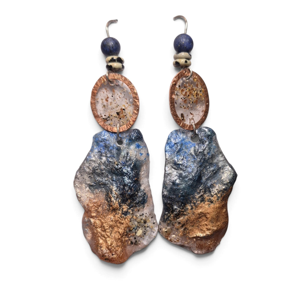 Loergann Studio artisan statement earrings with midnight blue and copper resin drops, hammered frames, and lapis beads.