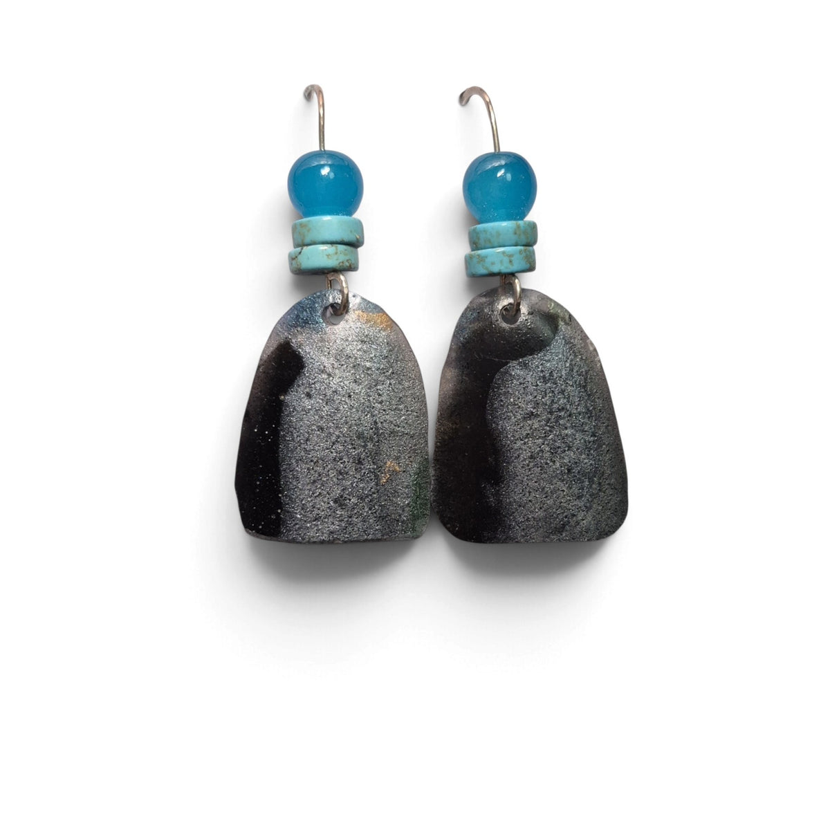 Loergann Studio artisan drop earrings with textured charcoal-grey shield pendants and vibrant turquoise bead accents.