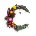 Loergann Studio crescent moon dried flower wreath with lavender, strawflowers, thistles, and a hanging crystal charm.