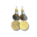 Loergann Studio artisan drop earrings with etched brass discs, blue enamel copper accents, and yellow and grey beads.